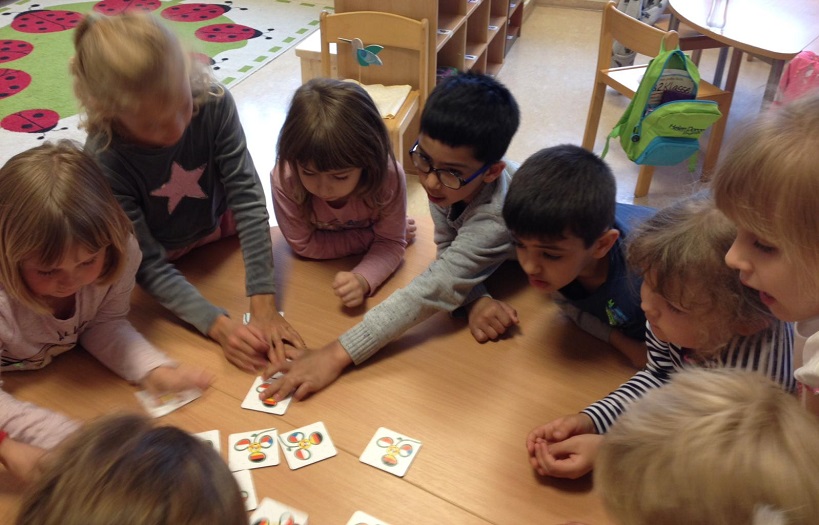 Kinder im Kindergarten der DPFA-Regenbogen-Schule Görlitz spielen gemeinsam an einem Tisch Memorie.